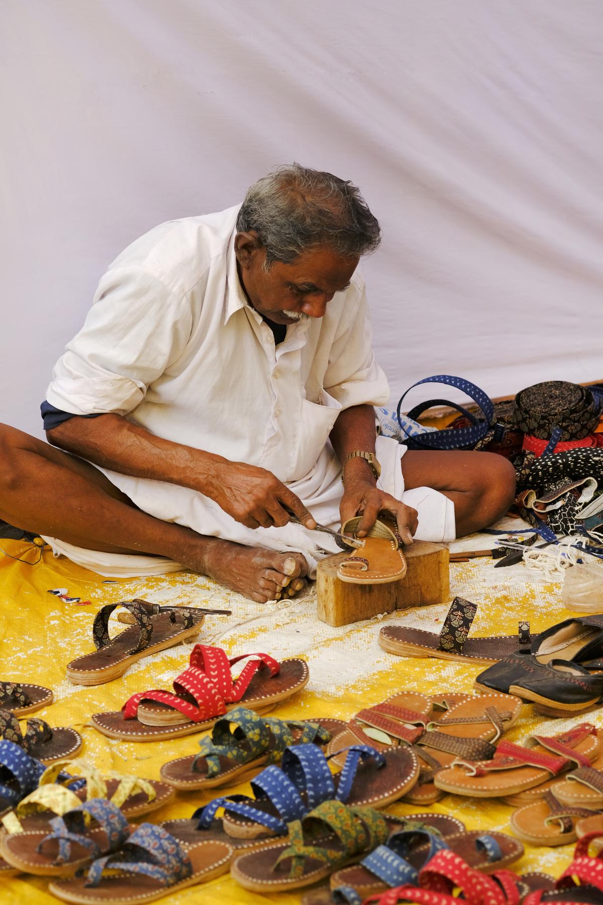 A traditional shoe maker making a traditional colourful shoes and slippers in Local Market. A traditional shoe maker making a traditional colourful shoes and slippers in Local Market.