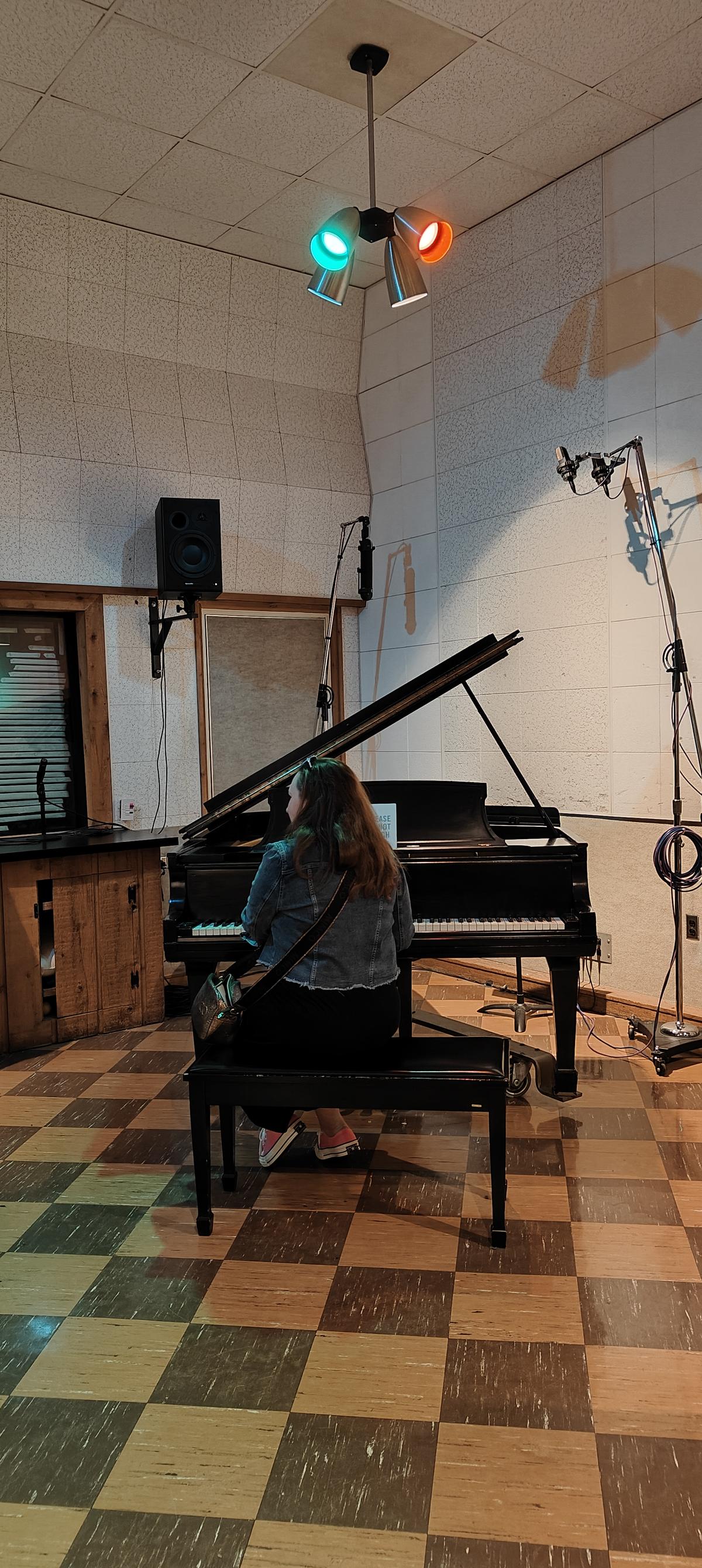 A visitor posing at Elvis Presley’s 1942 Steinway Piano