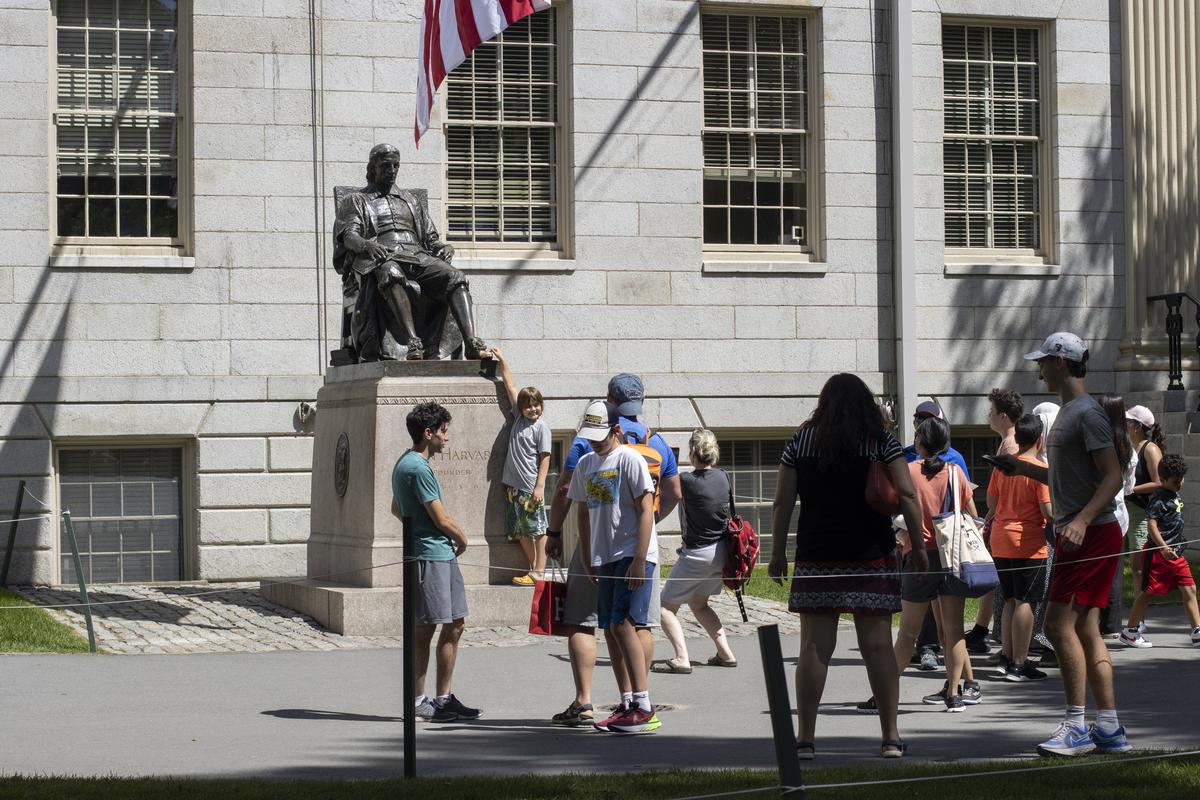 Visitors to the Harvard Yard, the oldest part of the Harvard University campus in Cambridge, Massachusetts, wait in line to take photos with the John Harvard Statue Visitors to the Harvard Yard, the oldest part of the Harvard University campus in Cambridge, Massachusetts, wait in line to take photos with the John Harvard Statue