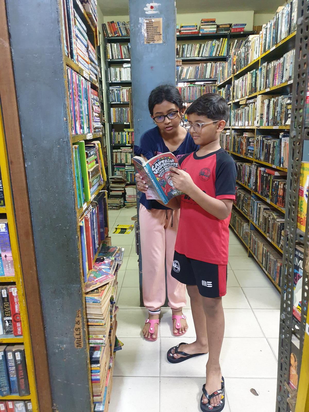 Ibrahim and Ayesha picking up a book at the library