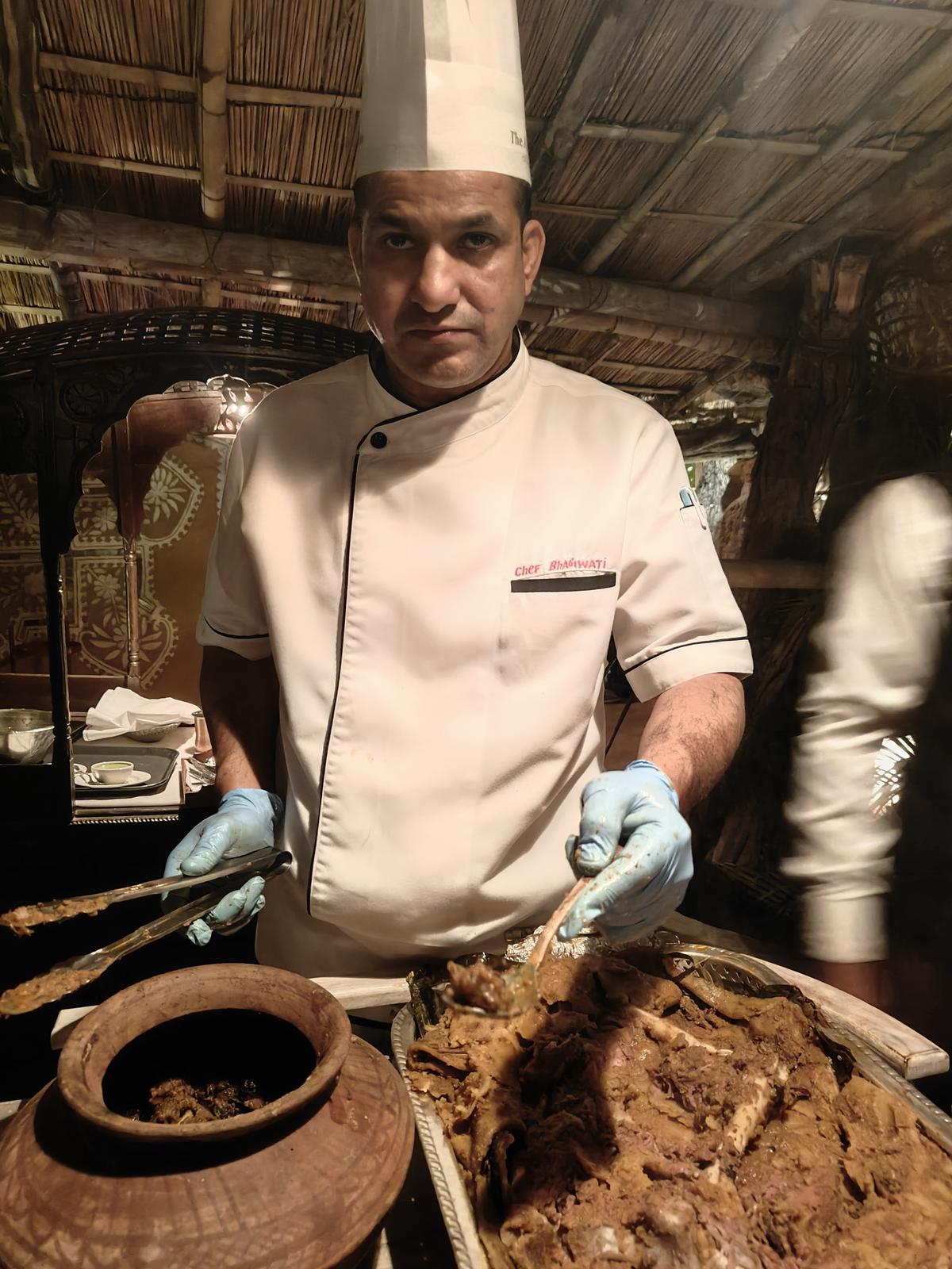 A chef unwraps meat that has been slow cooked underground at Ajit Bhawan