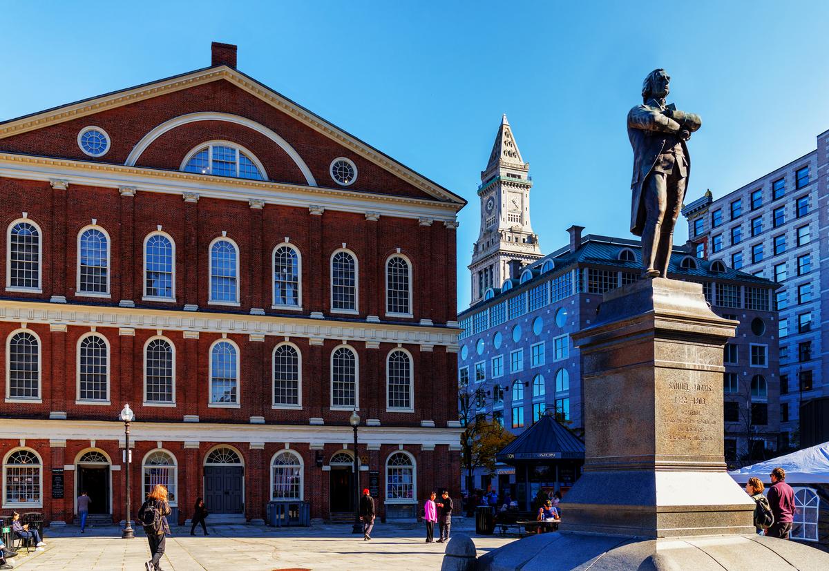 The Samuel Adams statue in front of the Faneuil Hall building in the Faneuil Hall Plaza. Samuel Adams (1722-1803) was an American Patriot who helped organize the American Revolution, signed the Declaration of Independence, and became Governor of Massachusetts. The Custom House Tower is in the background. The Samuel Adams statue in front of the Faneuil Hall building in the Faneuil Hall Plaza. Samuel Adams (1722-1803) was an American Patriot who helped organize the American Revolution, signed the Declaration of Independence, and became Governor of Massachusetts. The Custom House Tower is in the background.