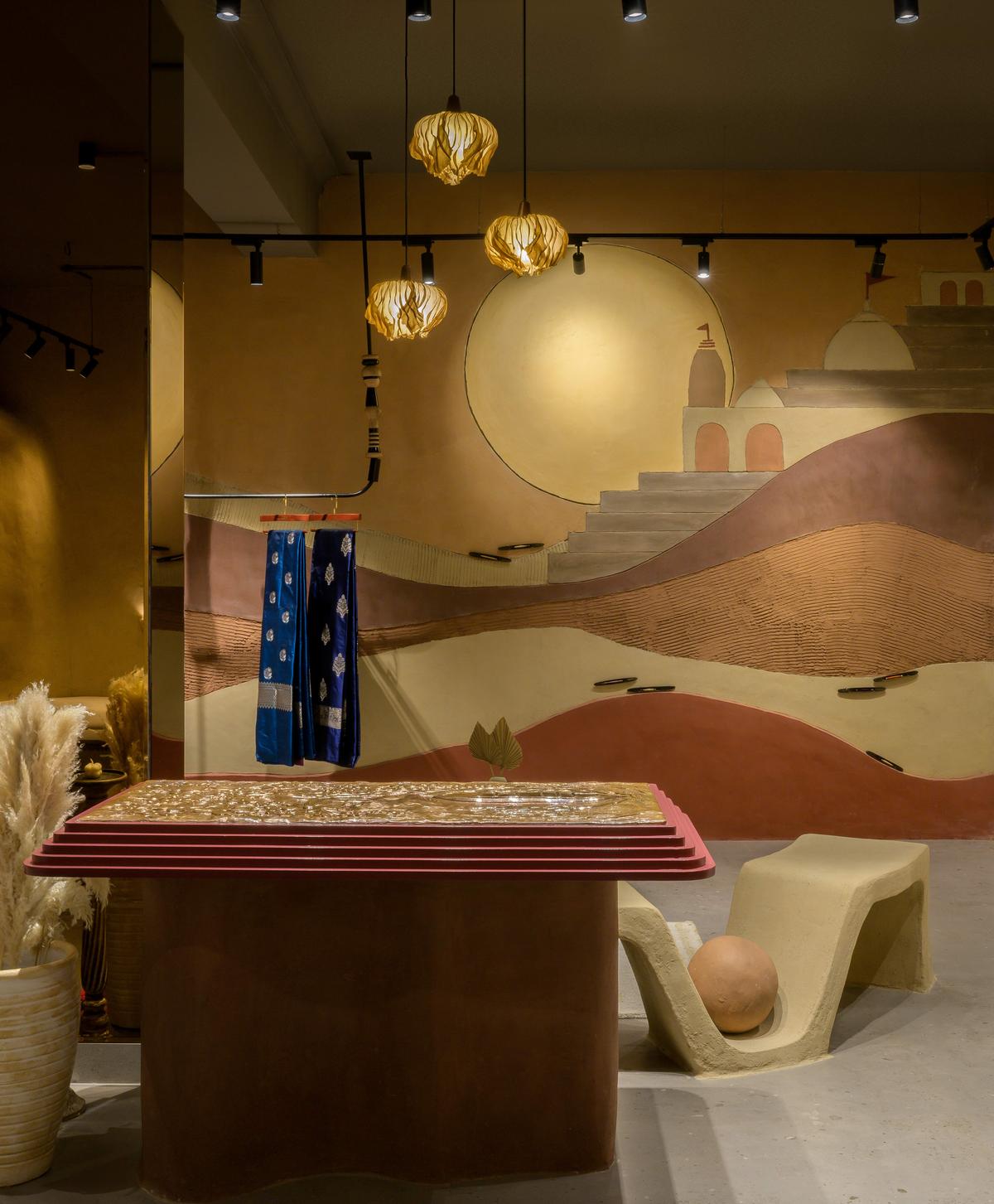 A large mural, an abstraction of Varanasi’s sunset in the ghats and display units made using lime and cow dung plasters infused with natural oxides A large mural, an abstraction of Varanasi’s sunset in the ghats and display units made using lime and cow dung plasters infused with natural oxides