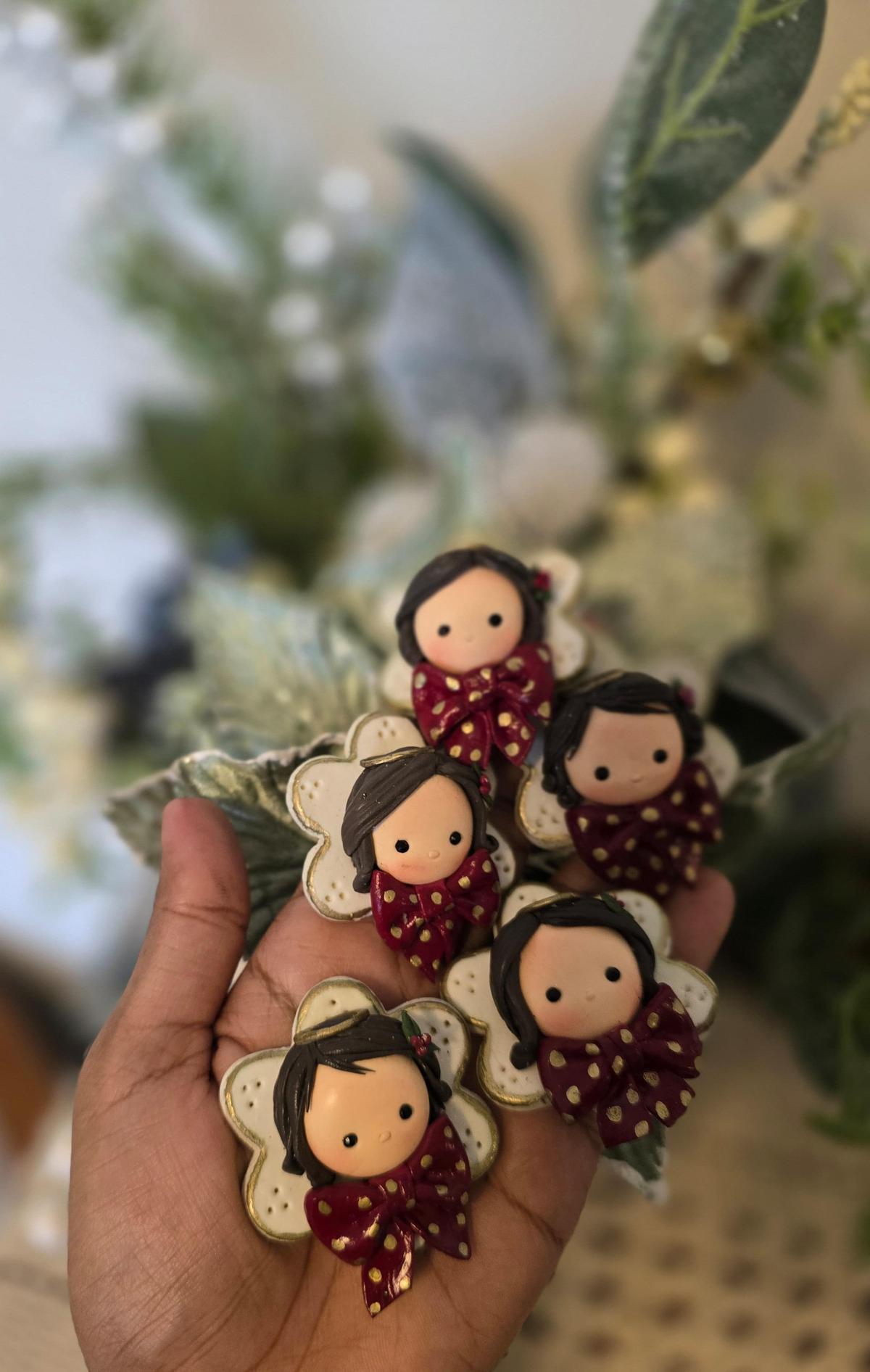 Ammu Chacko’s red bow angels made in clay