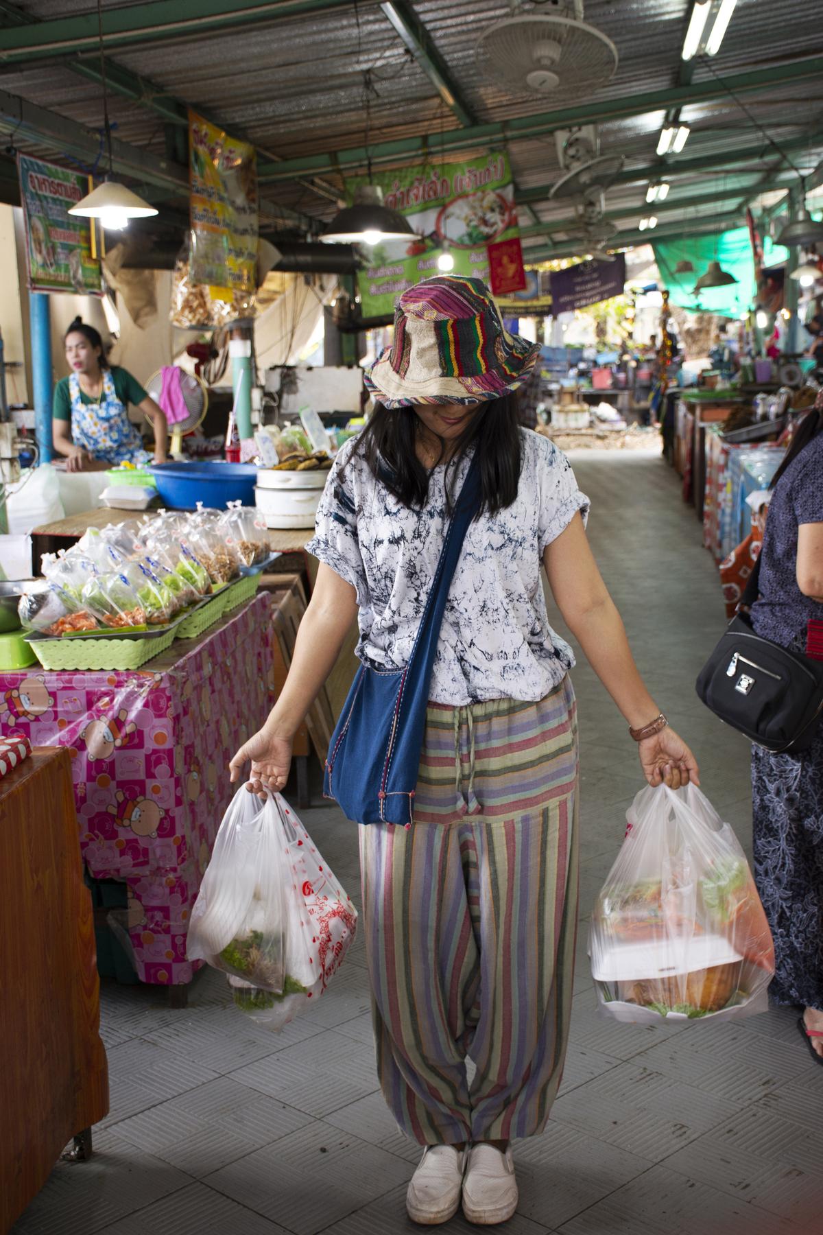 A tourist shopping for seafood and snacks at Don Hoi Lot seafood market in Samut Songkhram, Thailand