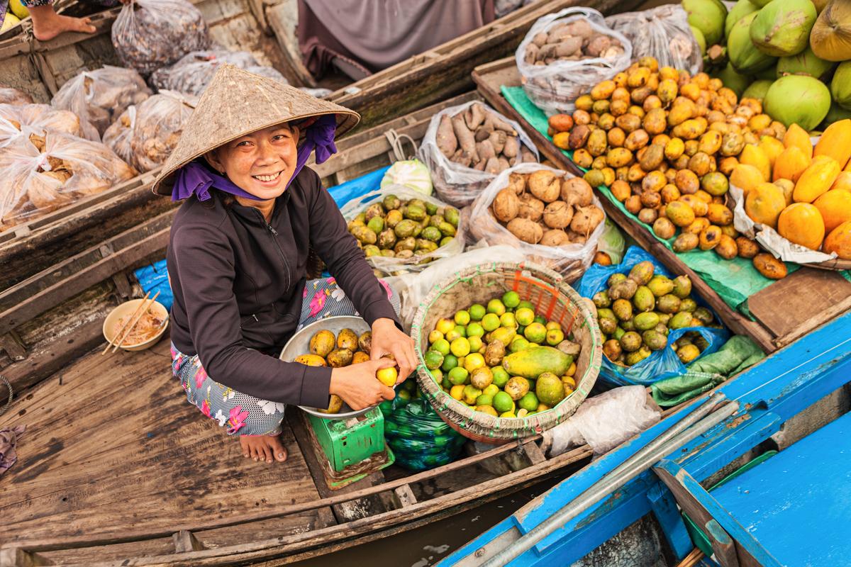 A woman selling fruit from her boat in the Mekong river delta, Vietnam