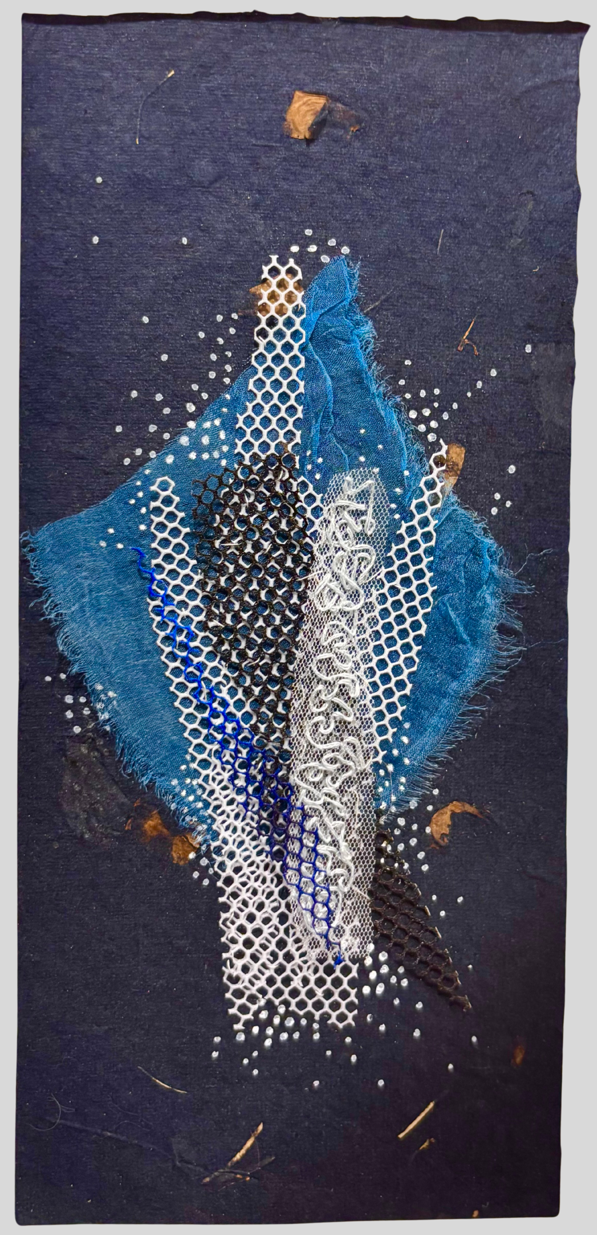 An artwork featuring embroidery on net, hand made paper