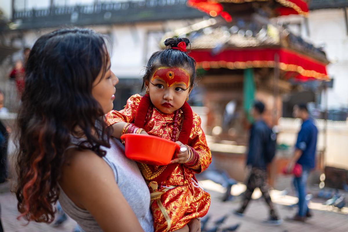 A little girl dressed as Kumari God feeding the pigeons at Kathmandu Durbar Square during Indra Jatra Festival A little girl dressed as Kumari God feeding the pigeons at Kathmandu Durbar Square during Indra Jatra Festival