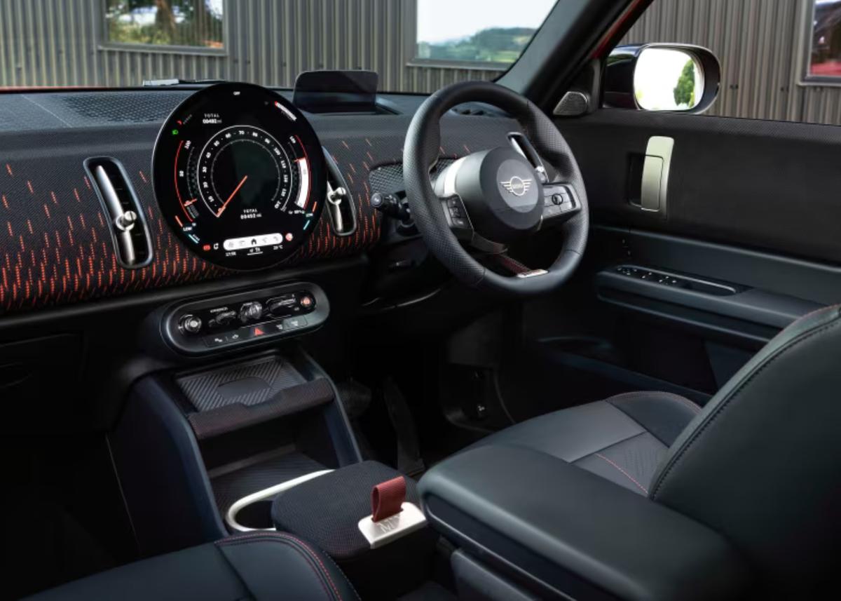 A circular OLED display, JCW sport seats, and playful design details create a cockpit that blends technology with character. A circular OLED display, JCW sport seats, and playful design details create a cockpit that blends technology with character.