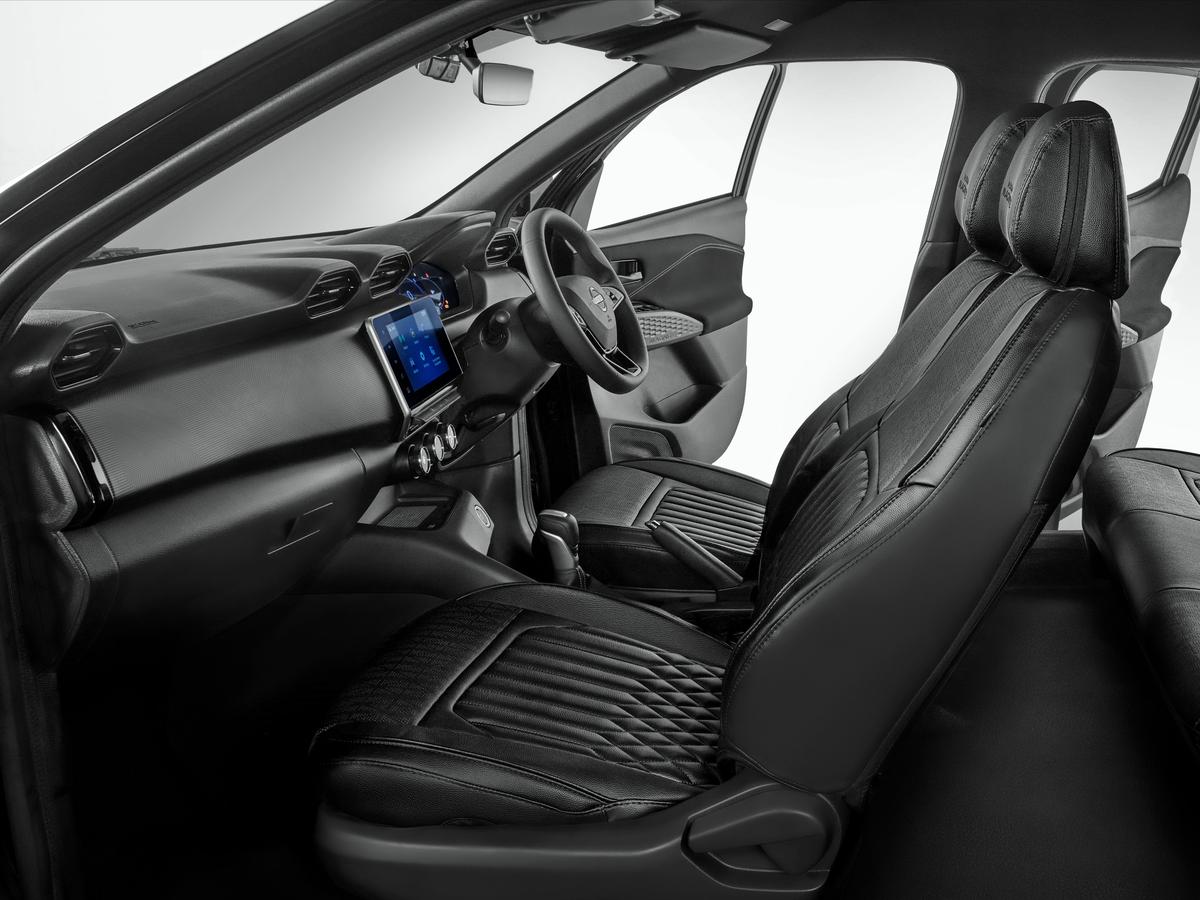 The cabin continues the blacked-out theme with a dark dashboard, piano black accents on the gear shift and steering, and black door trims and sun visors.
