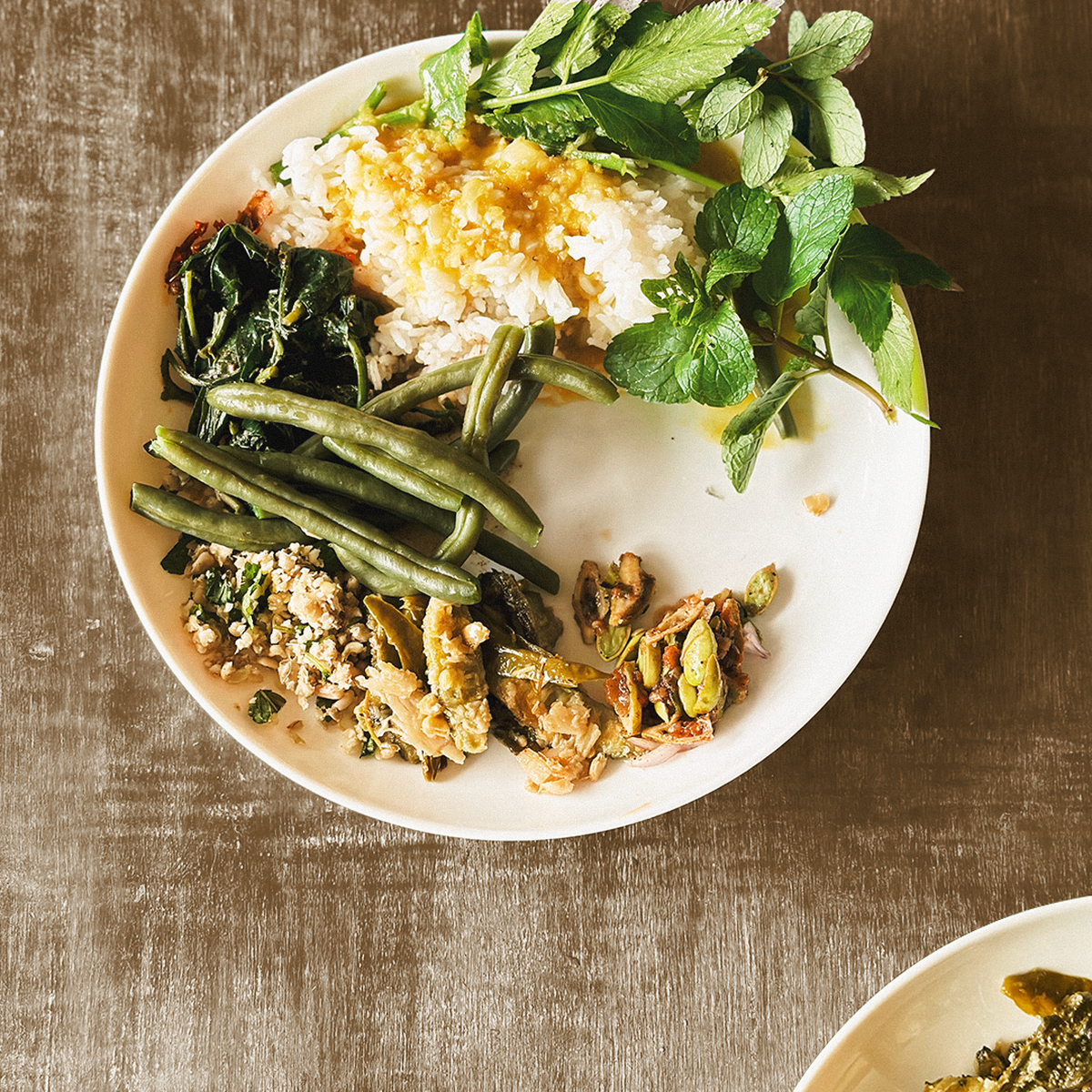 A Naga thali featuring steamed rice and dal, with a side of mint, steamed beans and roasted stinky beans salad with Naga king chilli