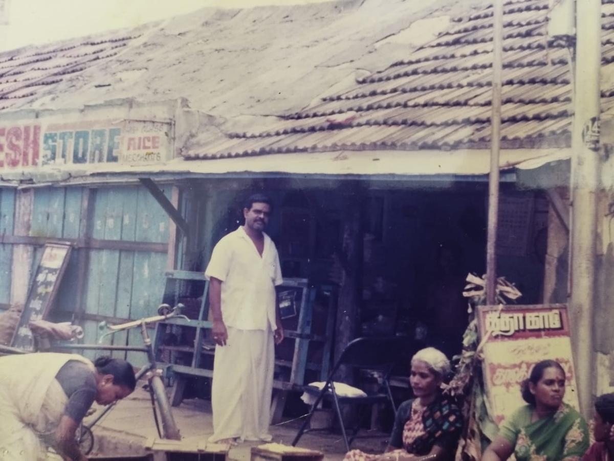 A Krishnamurthy poses in front of his old shop in 2001