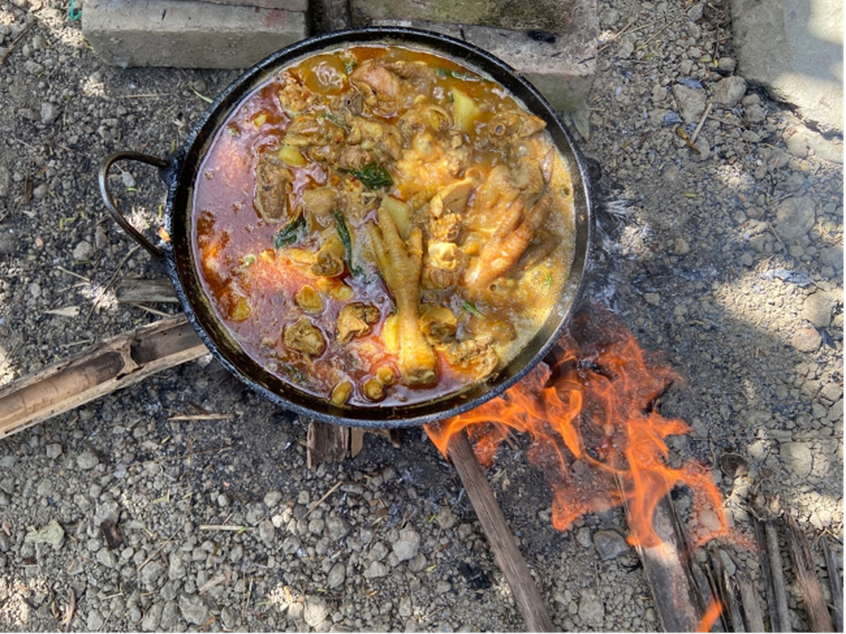 Cooking chicken curry over a fire