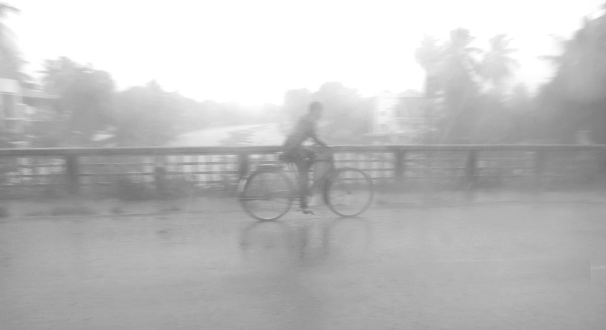 A man crosses the old Champakkara bridge on his bicycle in Kochi