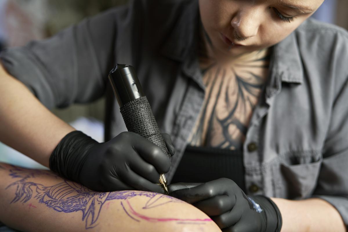 stop tattoo artist drawing on client's arm
