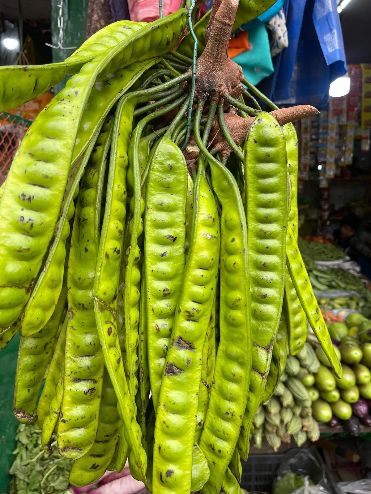 Hyper-local and wild produce is foraged and brought to the market daily.  This is yongchak, commonly called stink bean.  Prepared as a quick stir-fry, it is also known to have medicinal quantities.