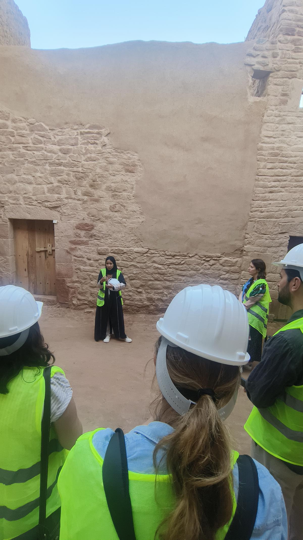 A guide walking visitors through the restored Old Town of AlUla