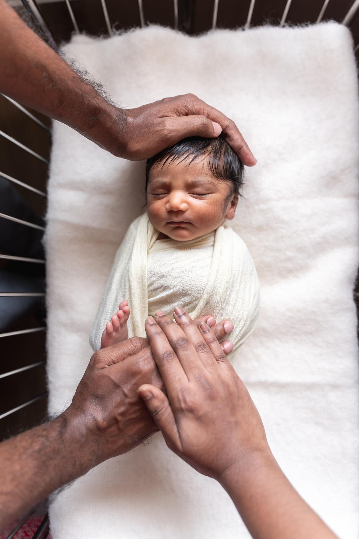 The baby seen in the hospital cradle. 