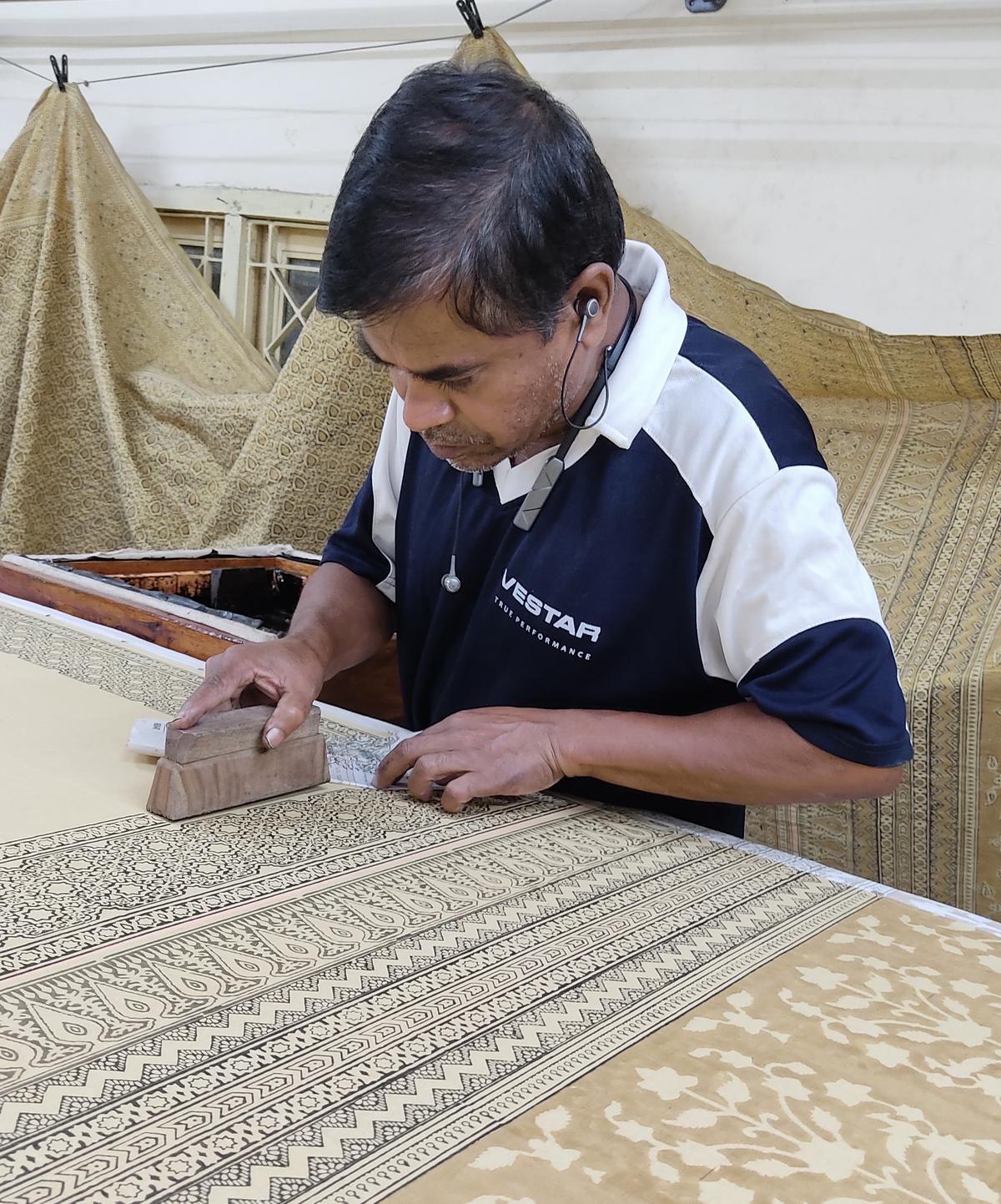 An artisan at working on natural dye block printing on a kodalikaruppur saree at the Aksh Weaves and Crafts studio 