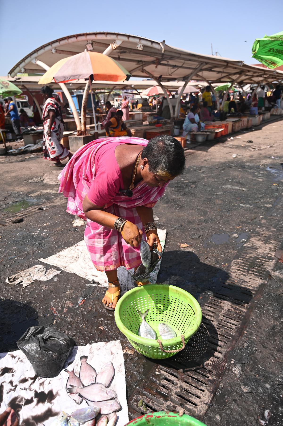 Valli buys paarai fish at the market