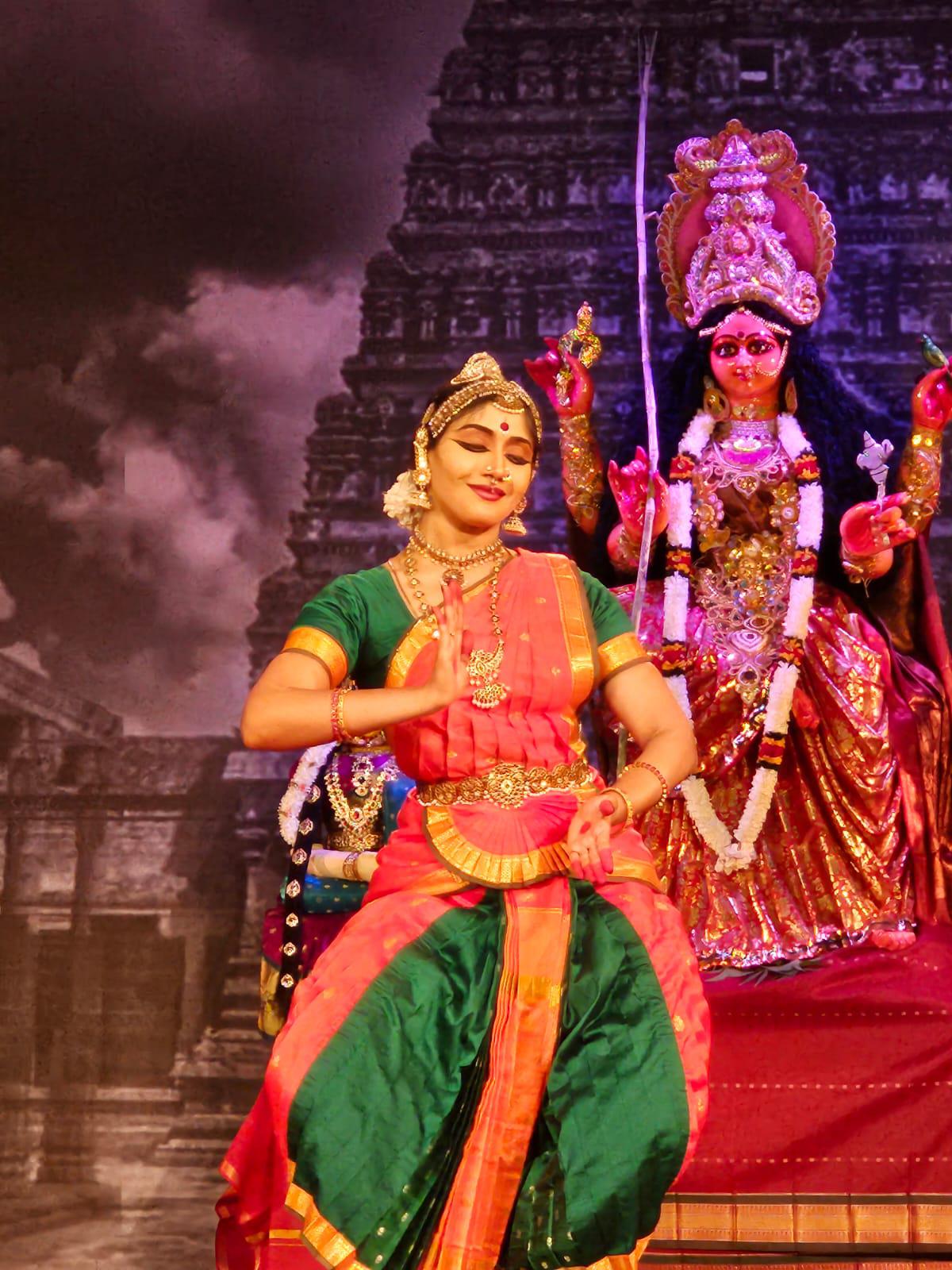 A dancer dances in front of Krishna Gana Sabha’s idol
