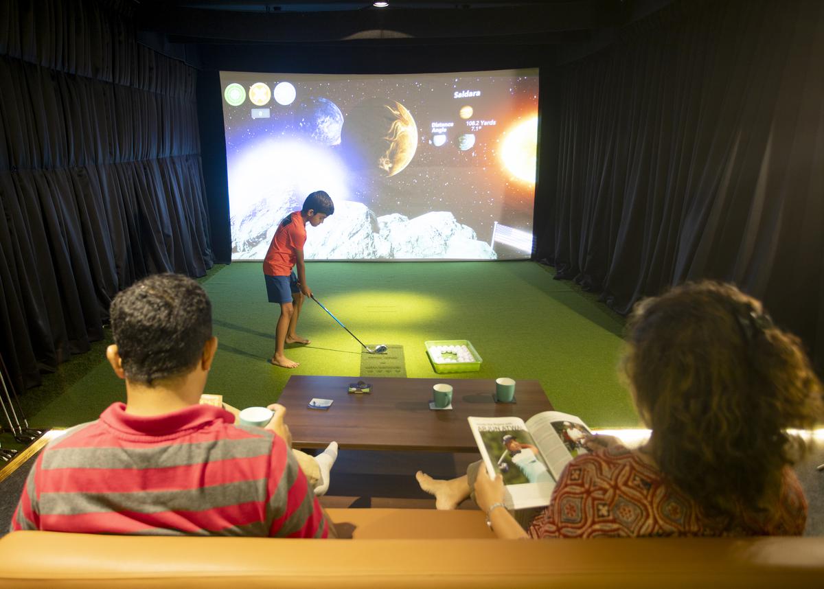 A child gets a feel of mini golf assisted by a simulator
