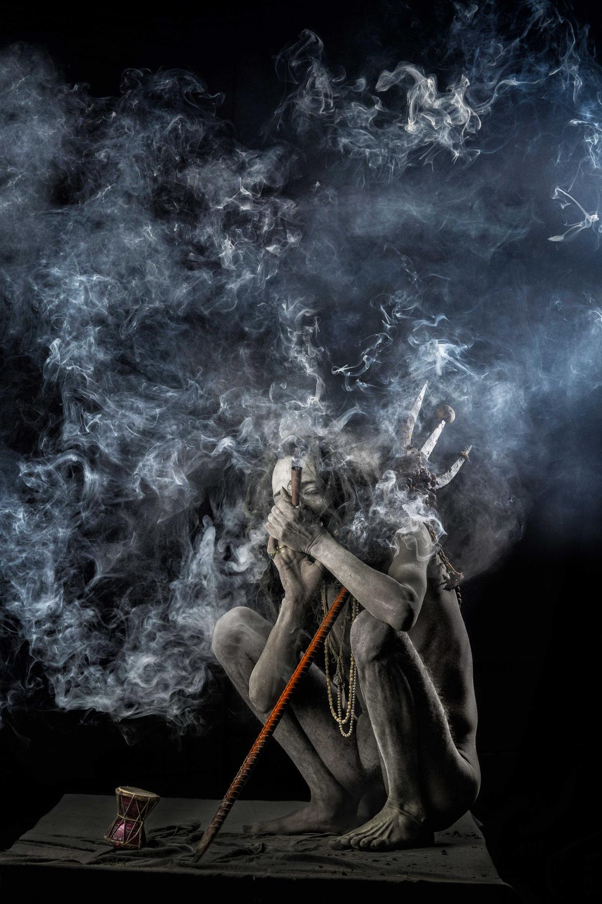 A Naga sadhu smoking a chillam