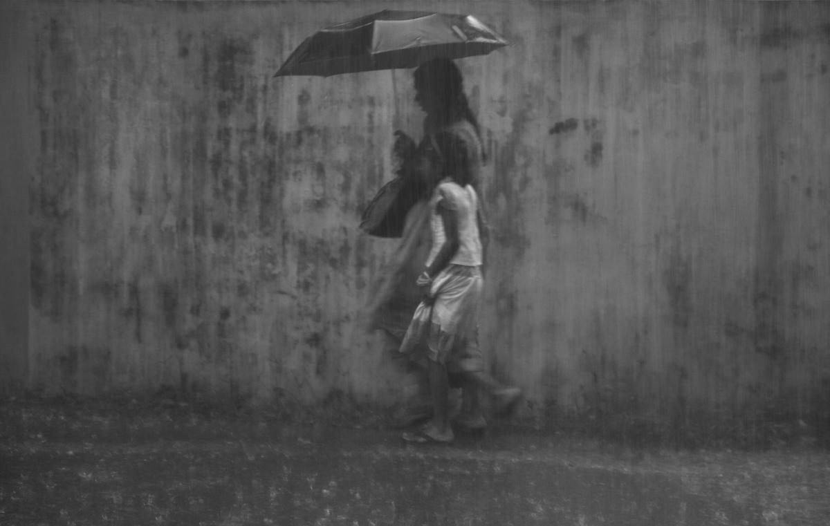 A woman and child walk in the heavy rain in Kochi