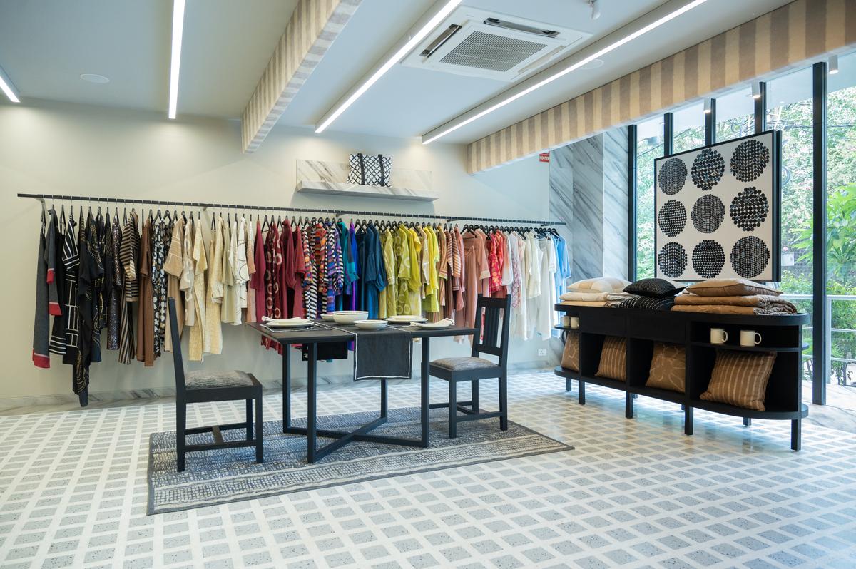 An open closet lines the store’s walls which are mounted with garment rods. Black shelves are dedicated to dainty ceramics, while linens and carpets accentuate the furniture that fills the store’s remaining space. 