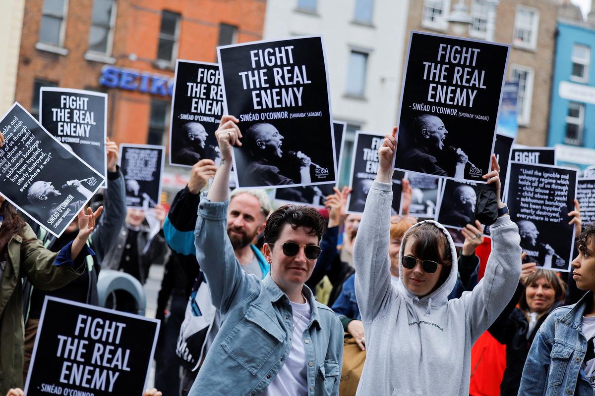 Fans hold up signs as they gather to pay tribute to late Irish singer Sinead O’Connor