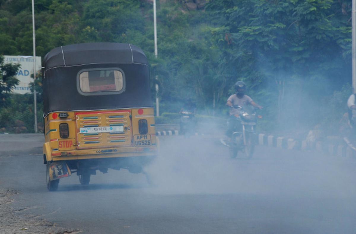 Busy street with traditional, polluting auto rickshaws