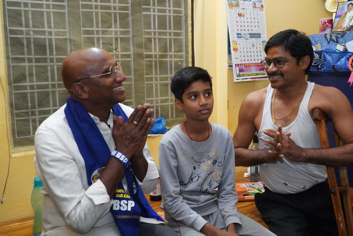 BSP Telangana president R.S. Praveen Kumar interacts with a person with disabilities during door-to-door campaign in Sirpur Kagaznagar from where he is contesting. 