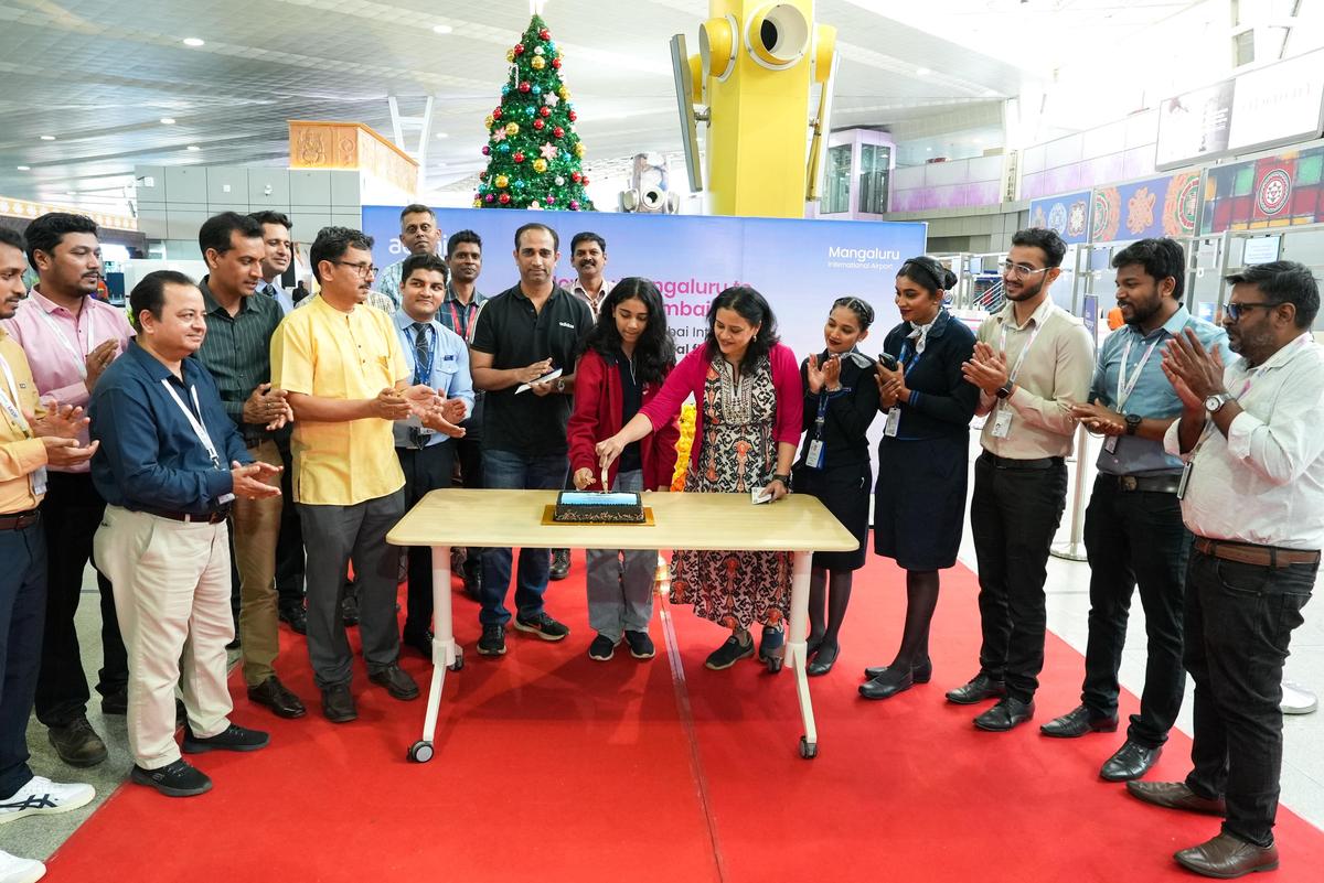A family on the inaugural Mangaluru to Navi Mumbai flight cutting cake at the departure hall of Mangaluru International Airport on December 25. A family on the inaugural Mangaluru to Navi Mumbai flight cutting cake at the departure hall of Mangaluru International Airport on December 25.