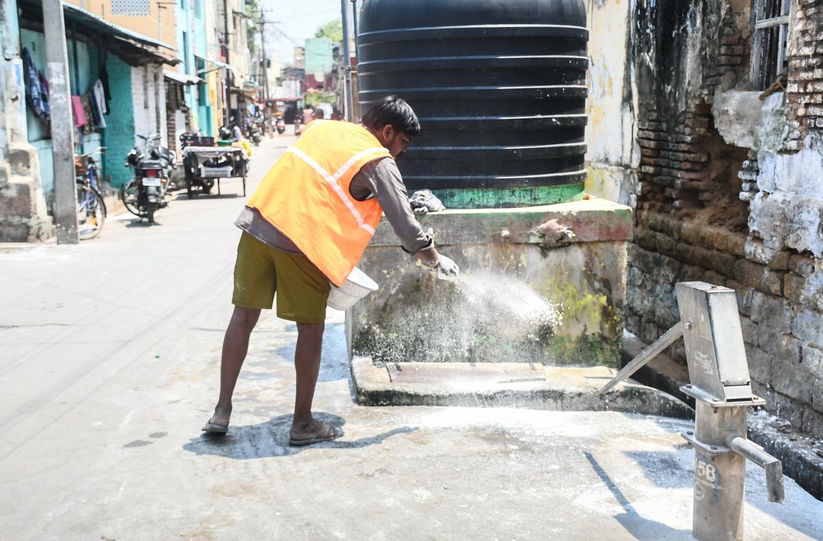 A sanitation worker cleaning the space near water tank in Woraiyur on Sunday. A sanitation worker cleaning the space near water tank in Woraiyur on Sunday.