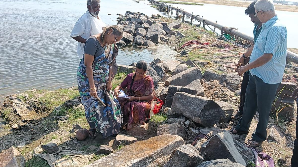 डॉ. एम. राजामणिक्कनर सेंटर फॉर हिस्टोरिकल रिसर्च, तिरुचि के शोधकर्ता, तिरुचि में मुसिरी के पास कावेरी नदी के तल में एक पत्थर के स्लैब पर पाए गए शिलालेखों को पढ़ रहे हैं।