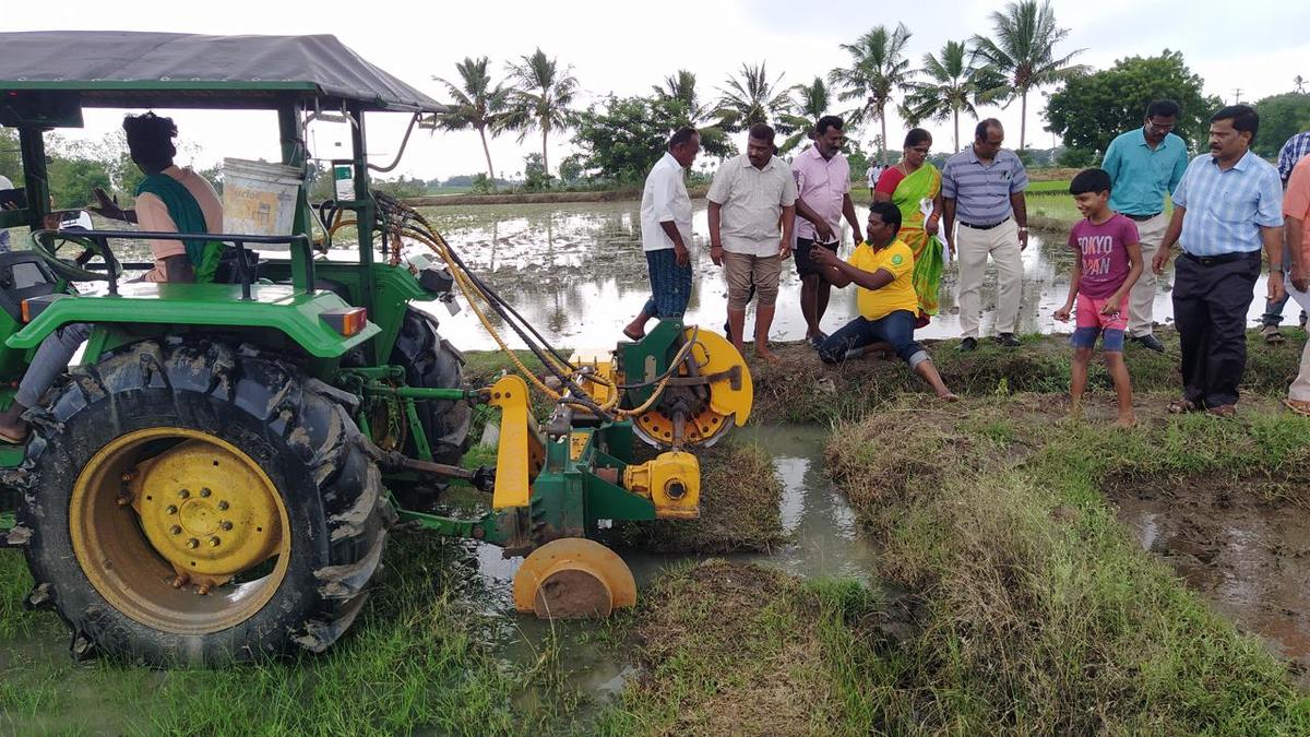 Farm institute faculty give a demonstration of ridge plastering machine to paddy farmers in Lalgudi