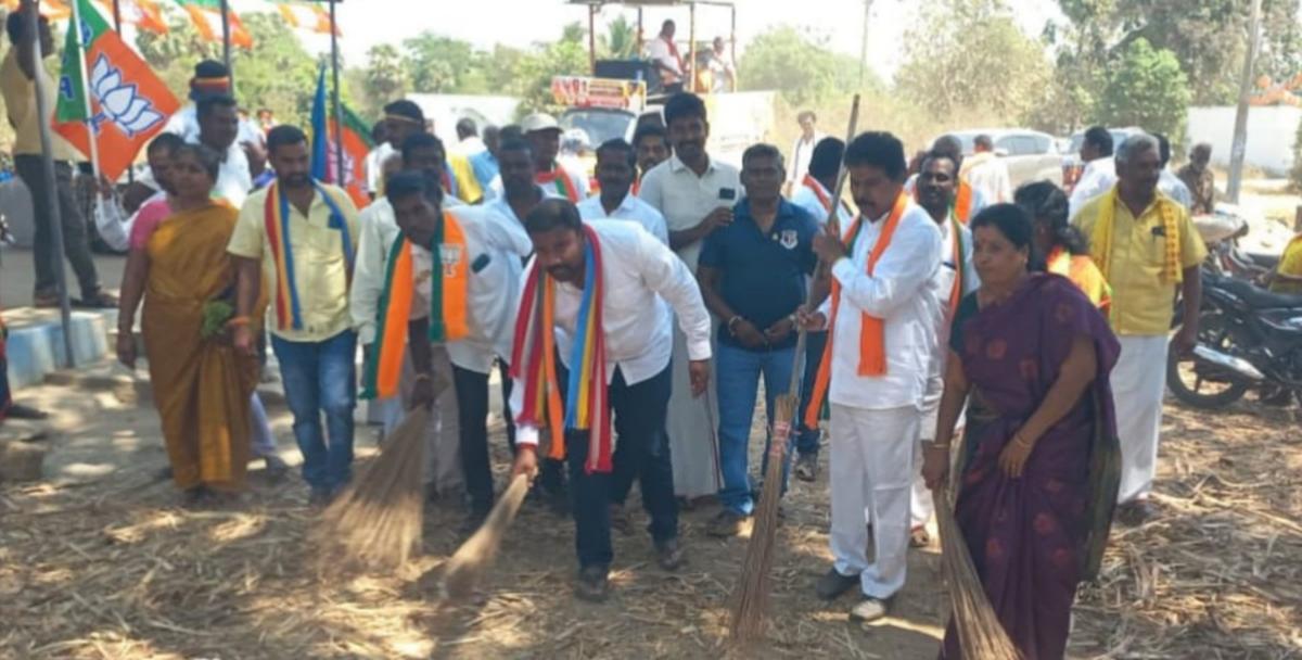 PMK candidate A. Ganesh Kumar sweeps a few streets in Vettiyantholuvam village near Arani town along with sanitary workers.