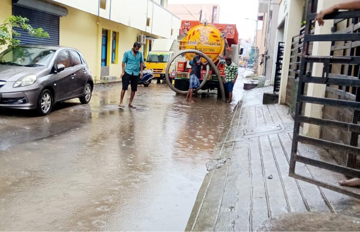 Corporation workers draining rainwater from a street using a pump at Roja Nagar in Madhavaram on Tuesday. Corporation workers draining rainwater from a street using a pump at Roja Nagar in Madhavaram on Tuesday.