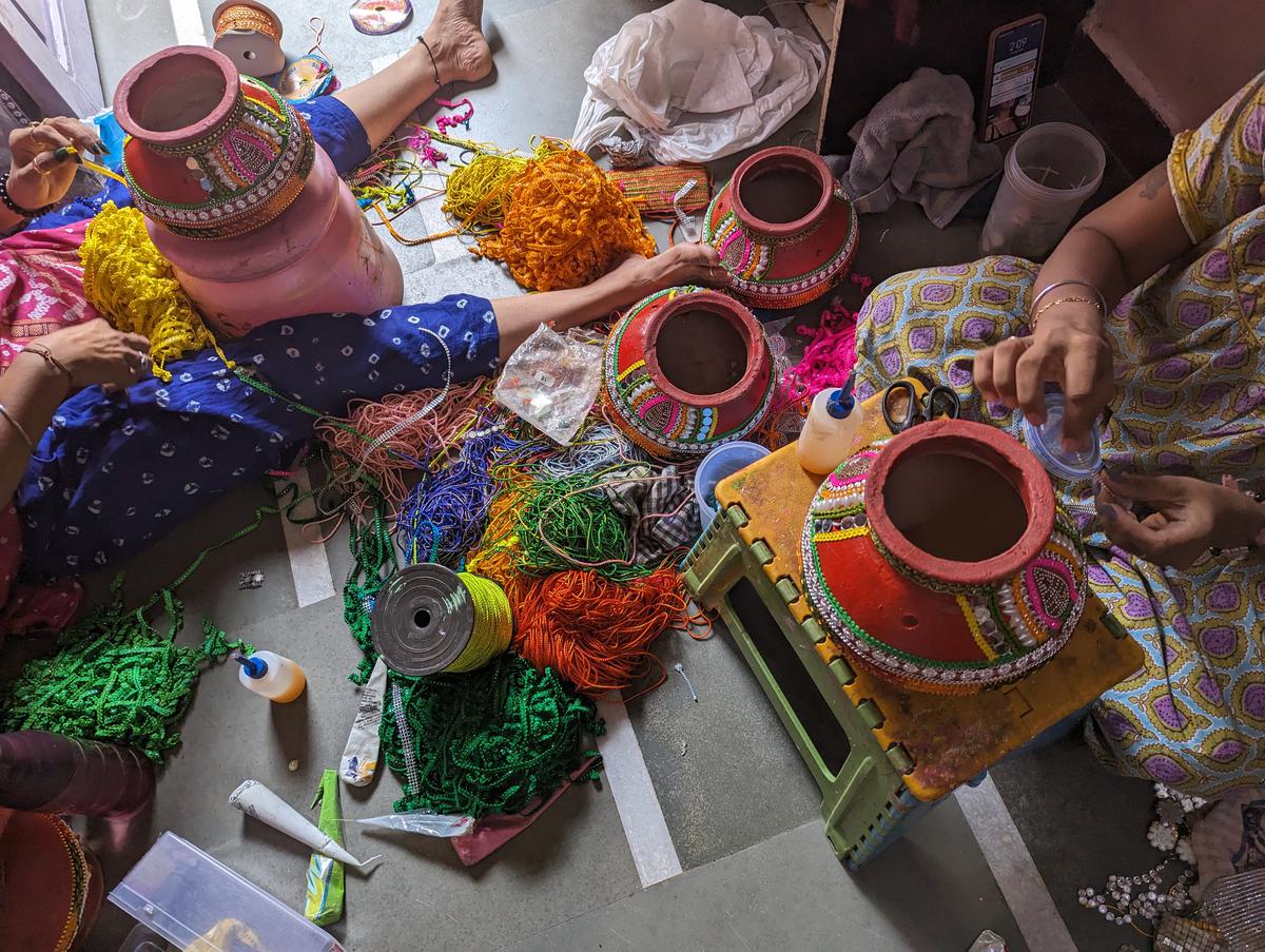 Women decorating garba pots.