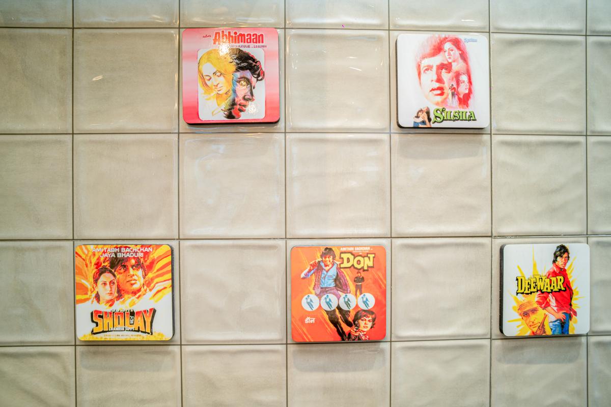 Coasters of Bollywood classics like Don, Sholay, Deewar, Silsila and Abhimaan stuck on the wall.