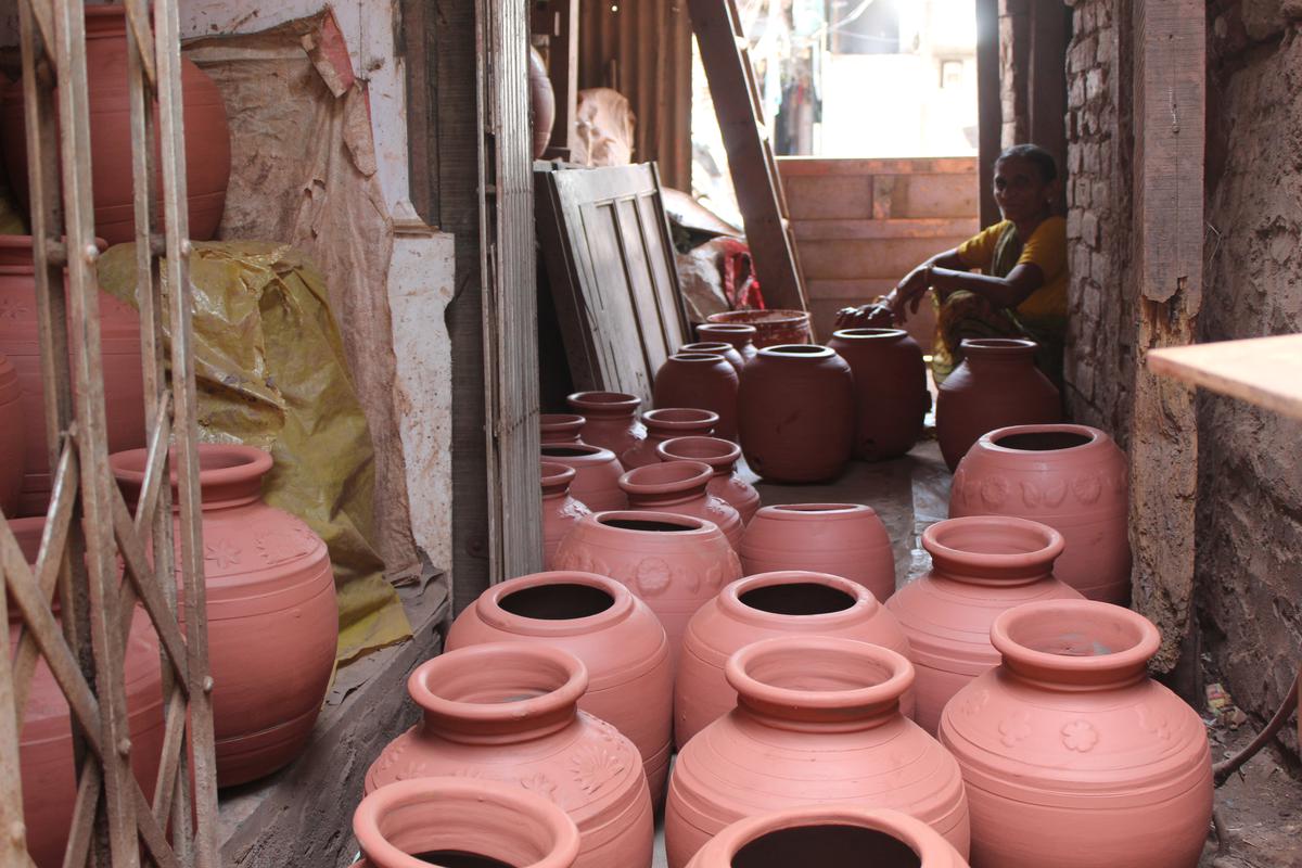 Women are polishing clay pots to keep them out in the sun.