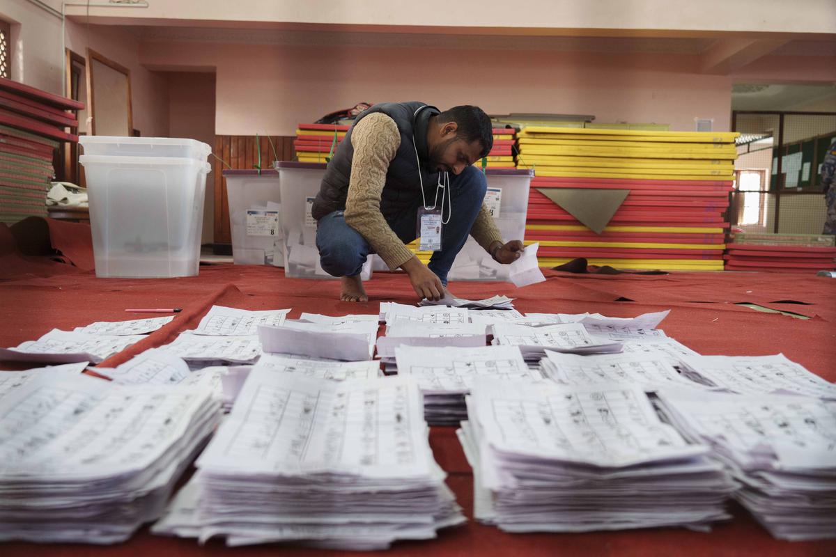 21 नवंबर, 2022 को काठमांडू में आम चुनाव के एक दिन बाद गिनती के लिए मतपत्रों को अलग करता चुनाव आयोग का कर्मचारी।