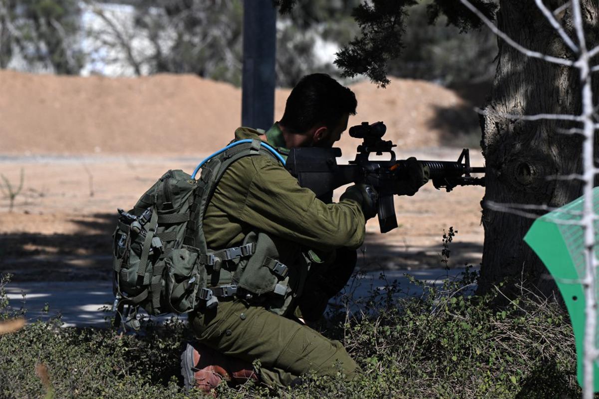 A picture taken during a media tour organised by the Israeli military shows a soldier securing a position at the Nir Oz kibbutz, one of the Israeli communities near the Gaza Strip attacked on October 7 by the Palestinian militant group Hamas, on October 30, 2023. 