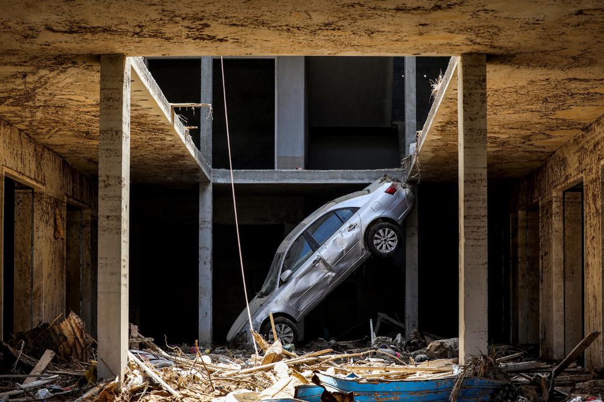 A tilted car sits above debris in Libya’s eastern city of Derna on September 18, 2023, following deadly flash floods