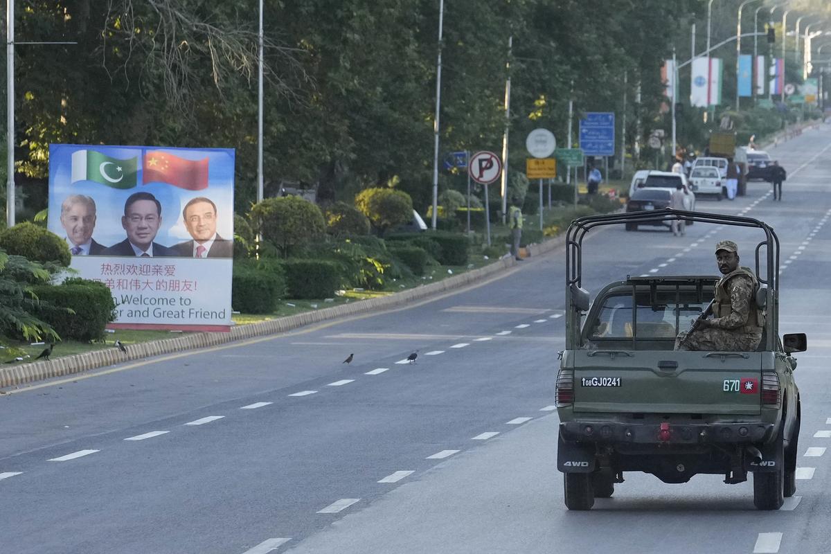 An army vehicle moves past a welcoming billboard with portraits of China’s Premier Li Qiang, Pakistan’s Prime Minister Shehbaz Sharif and President Asif Ali Zardari, displayed along a road leading to the venue of the upcoming Shanghai Cooperation Organization (SCO) summit in Islamabad.