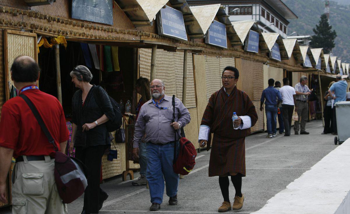 File photo of a group of foreign tourists with a local guide walking past a row of shops selling handicrafts in Thimphu. 
