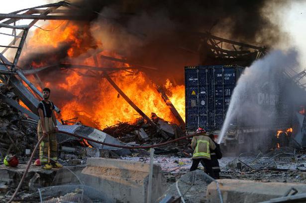 Firefighters douse a blaze at the scene of an explosion at the port of Lebanon's capital Beirut on August 4, 2020.