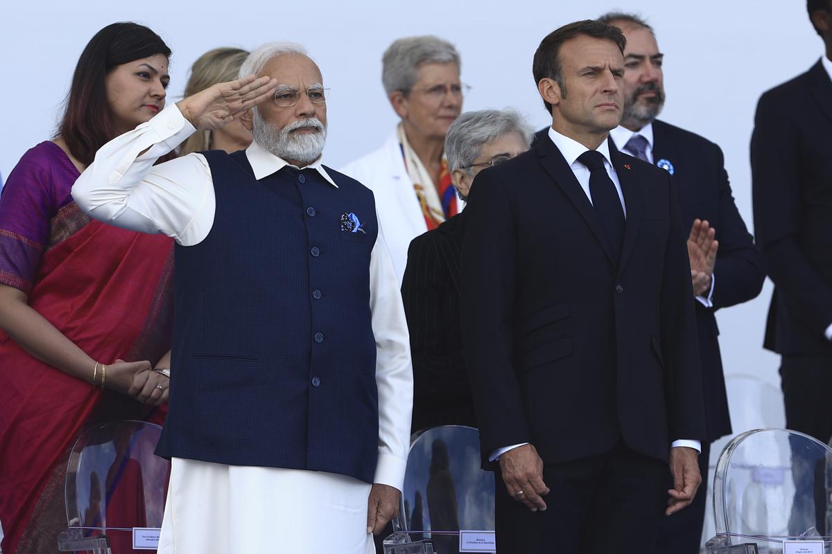 Prime Minister Narendra Modi salutes Indian troops as French President Emmanuel Macron looks on during the Bastille Day military parade on July 14, 2023.