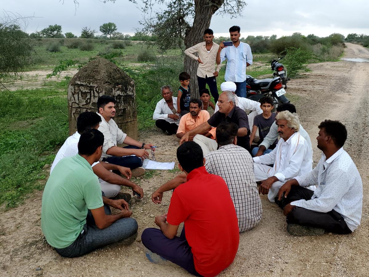 Dr. Rohit Jindal (left) interacting with the villagers next to the Oran in Ramrawas Kalan. 