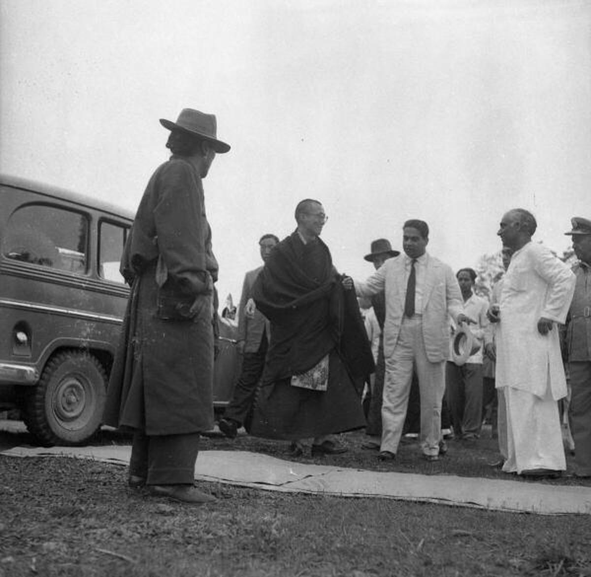 Wearing his dark robes, the Dalai Lama (23) with the External Affairs Ministry official P.N. Menon. (in white suit), who is escorting him. K.N. Tripathi, Minister for Labour, Assam Government, is also seen. The photo was taken when he reached Tezpur in Assam on April 18, 1959. Wearing his dark robes, the Dalai Lama (23) with the External Affairs Ministry official P.N. Menon. (in white suit), who is escorting him. K.N. Tripathi, Minister for Labour, Assam Government, is also seen. The photo was taken when he reached Tezpur in Assam on April 18, 1959.